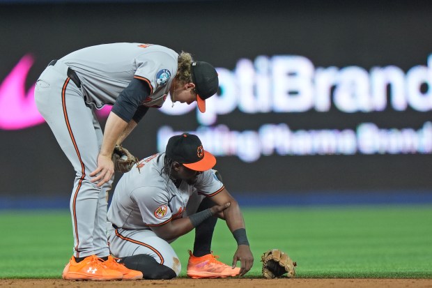 Baltimore Orioles shortstop Gunnar Henderson, left, checks second baseman...