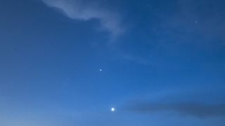 a dark blue sky with thin, wispy clouds and two bright points of light, one is Venus and the other Mercury.