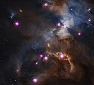 A cloudy area of ​​space with some bright pink dots throughout.