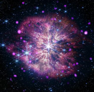 A bright pink explosion appears to occur in space. There is a bright area right in the center of the explosion.