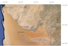 View of a desert landscape with a river at the northern end and another former river marked by a break in the dune patterns.