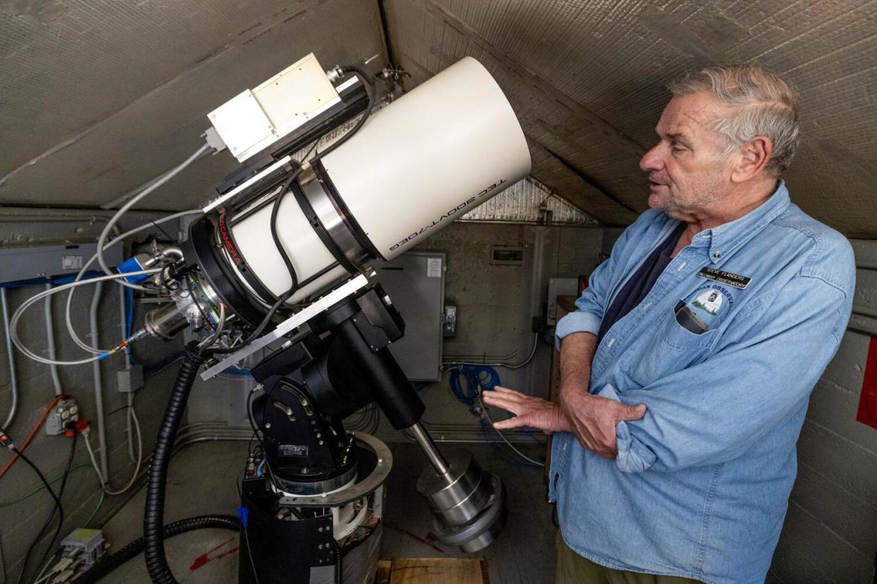 Steve Flanders shows the Gattini-IR telescope inside a small building at Palomar Observatory.