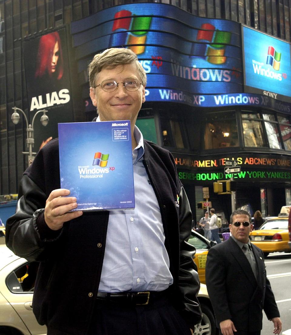 (FILES) This file photo shows Microsoft Chairman Bill Gates holding a copy of the new Windows XP operating system while posing for photos in Times Square in New York during the launch of Windows XP on October 25, 2001 in New York. Microsoft and the U.S. Justice Department have agreed on the framework of a settlement in the government's marathon antitrust trial against the software giant, with a federal judge ordering negotiations to be concluded by November 2, 2001. AFP PHOTO Henny Ray ABRAMS (Photo by HENNY RAY ABRAMS / AFP) (Photo by HENNY RAY ABRAMS/AFP via Getty Images)