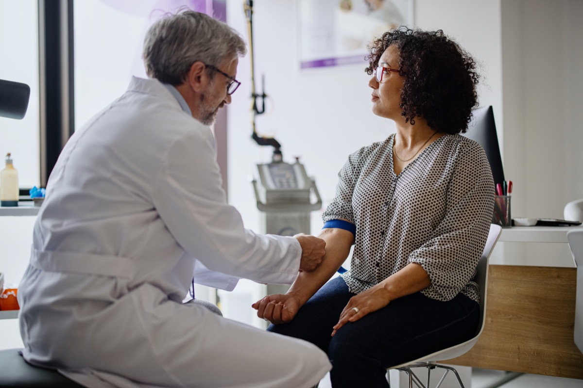 A woman has her blood pressure taken by a doctor