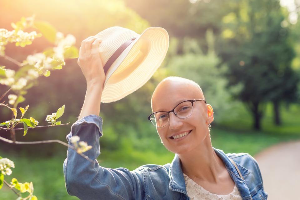 Person smiling and taking off his hat.