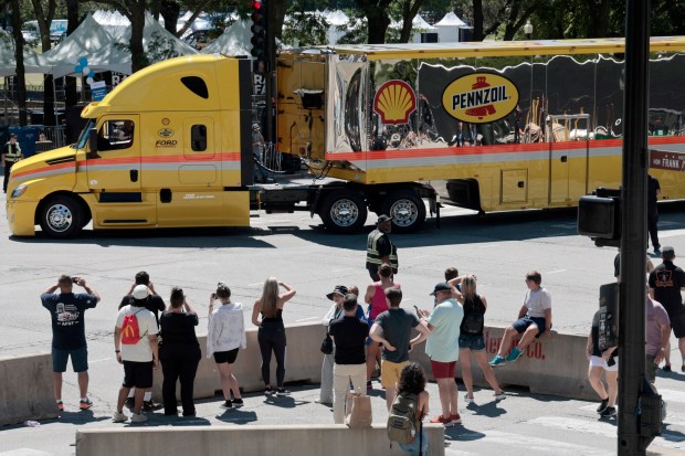 Crowds watch Columbus Drive and Monroe Street as trucks arrive with race cars to be unloaded from trucks in preparation for the NASCAR street race in Chicago, July 5, 2024. (Antonio Perez/Chicago Tribune)