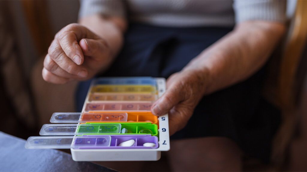 Person sorting pills into a container