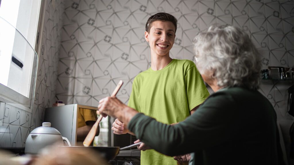 Grandson cooking with grandmother in the kitchen