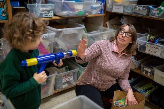 Alex Lynn, five, plays with her mother, April Beaton, while shopping at Arts & Scraps in Detroit on Friday, Feb. 16, 2024. Beaton adopted Alex and her 4-year-old son, Jacob, from foster care and has learned what kind of support they need to thrive despite the various ways adverse childhood experiences have played out in their lives.