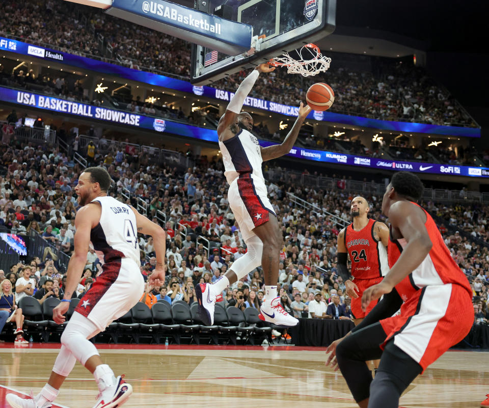 LAS VEGAS, NEVADA - JULY 10: LeBron James #6 of the United States dunks over Dillon Brooks #24 and RJ Barrett #9 of Canada on an alley-oop pass from Stephen Curry #4 in the second half of their exhibition game prior to the Paris Olympic Games at T-Mobile Arena on July 10, 2024 in Las Vegas, Nevada. The United States defeated Canada 86-72. (Photo by Ethan Miller/Getty Images)