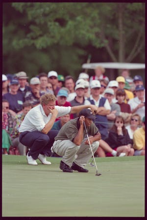 Tiger Woods lines up his putt with Colin Montgomerie watching behind him during the 1997 Masters.