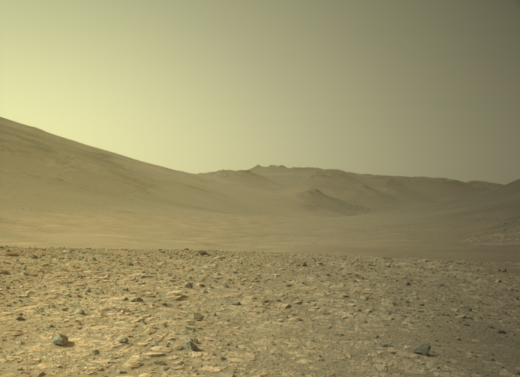 A brown rocky landscape and a yellowish sky.