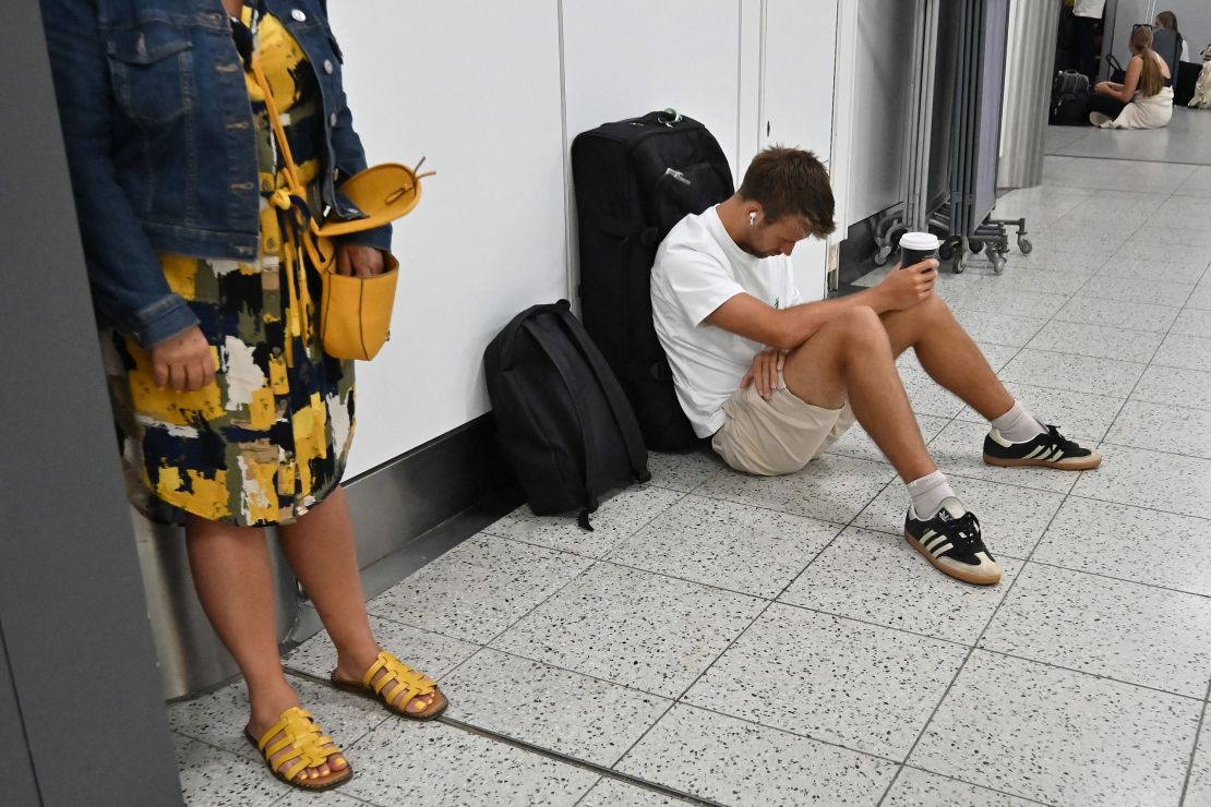 A passenger waits in the check-in area of ​​Gatwick Airport as some flights are cancelled or delayed, in Horley, south of London, July 20, 2024.