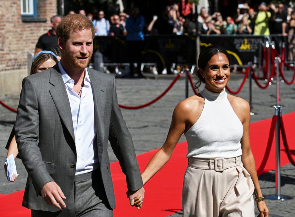 Prince Harry and Meghan Markle walk outside City Hall as they attend the 