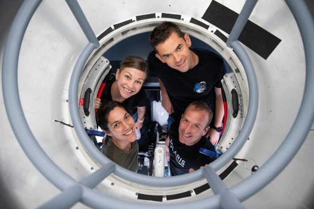 From left, Sarah Gillis, Anna Menon, Jared Isaacman and Scott Poteet pose for a portrait in a spacewalk training simulator. (Photo courtesy of SpaceX).