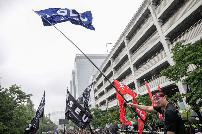 Union members wave flags outside a Samsung factory during a strike 